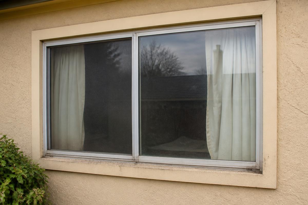 Demo photo of an old aluminum window before replacement